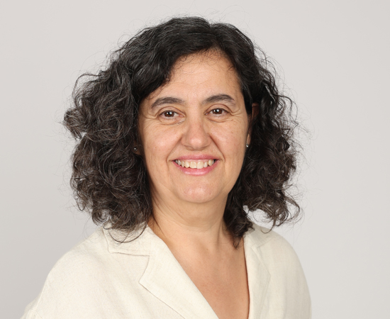 Cristina Llopart, de CristinaConnecta, somrient de cara a la càmera sobre un fons gris clar.